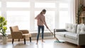 Young woman housewife clean floor in modern living room Royalty Free Stock Photo