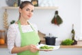 Young woman housewife cooking in the kitchen. Concept of fresh and healthy meal at home Royalty Free Stock Photo