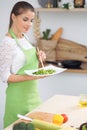 Young woman housewife cooking in the kitchen. Concept of fresh and healthy meal at home Royalty Free Stock Photo