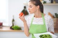 Young woman housewife cooking in the kitchen. Concept of fresh and healthy meal at home Royalty Free Stock Photo