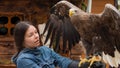 A young woman with a huge mountain eagle on her glove,
