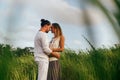 Young woman hugging asian man in the middle of a wheat field and kissing each other. Royalty Free Stock Photo