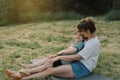 Young woman hugging her little son at sunny in the meadow. Royalty Free Stock Photo