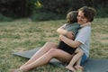 Young woman hugging her little son at sunny in the meadow. Royalty Free Stock Photo