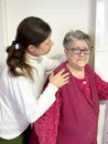 A young woman hugs an older woman, showing poignant affection and care. People of different ages Royalty Free Stock Photo