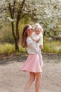 Young woman hugs two-year-old girl on natural background Royalty Free Stock Photo