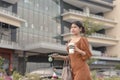 A young woman hurriedly walks by the company building bringing an iced coffee to work