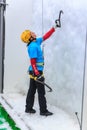 Young woman ice climber about to climb ice wall at ice climbing side-show attraction in Olympic