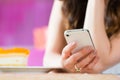 Young woman in ice cream parlor with phone texting