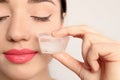 Young woman with ice cube on light background Royalty Free Stock Photo