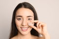 Young woman with ice cube on light background. Royalty Free Stock Photo