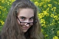 Young woman ihe looks mischievously over her glasses Royalty Free Stock Photo