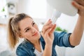 Young woman indoors at home, changing light bulb. Royalty Free Stock Photo