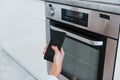 Young woman is indoors in smart house room controlling the oven Royalty Free Stock Photo