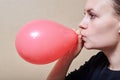 Young woman inflate a balloon, the theme of holidays and parties