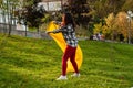 A Young woman Inflates A yellow Lamzac With Air. A woman Inflates An Air Sofa in park.