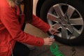 Young woman inflating car tire on street, closeup Royalty Free Stock Photo