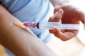 Young woman injecting syringe with sugar hearts in her arm. Concept of diabetes.