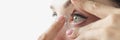 Young woman inserting contact lens into her eye closeup Royalty Free Stock Photo