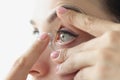 Young woman inserting contact lens into her eye closeup Royalty Free Stock Photo