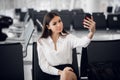 Young woman at international airport, making selfie with mobile phone and waiting for her flight. Royalty Free Stock Photo