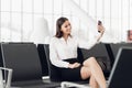 Young woman at international airport, making selfie with mobile phone and waiting for her flight. Royalty Free Stock Photo