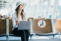 Young woman in international airport working on laptop while waiting for her flight Royalty Free Stock Photo