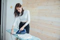 Young woman ironing laundry with an iron on an ironing board Royalty Free Stock Photo