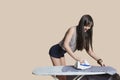 Young woman ironing shirt over colored background Royalty Free Stock Photo