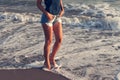 Young woman in jeans shorts walking through sea water at sunset sandy beach summer Royalty Free Stock Photo