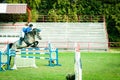 Young woman jockey ride beautiful white horse and jump over the crotch in equestrian sport. Royalty Free Stock Photo