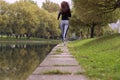 Young woman jogging in autumn nature on the bank of river. Running Fitness girl back view Royalty Free Stock Photo