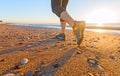 Young Woman jogging on Sand Beach along Sea Surf at Sunrise Shoes Close Up Royalty Free Stock Photo