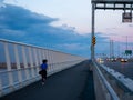 A young woman jogs on the pedestrian lane on Montreal`s new Champlai Bridge Royalty Free Stock Photo