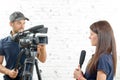 Young woman journalist with a microphone and cameraman Royalty Free Stock Photo