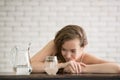 Young woman in joyful postures with jug and glass of drinking water