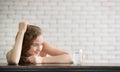 Young woman in joyful postures with jug and glass of drinking water