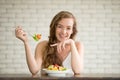 Young woman in joyful postures with salad bowl on the side