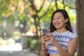 young woman texting on her cellphone and laughing at the camera