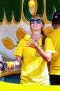 Young woman juggles three lemons in a lemonade stand