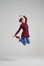 Young woman jumping in the air happily at studio Royalty Free Stock Photo