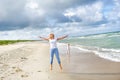 Young woman jumping on the beach of the Baltic Sea in Lithuania. Little girl stroll along the beach Royalty Free Stock Photo