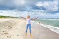 Young woman jumping on the beach of the Baltic Sea in Lithuania Little girl stroll along the beach. Royalty Free Stock Photo