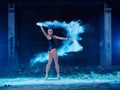 Young woman jumping in blue powder cloud Royalty Free Stock Photo