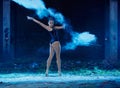 Young woman jumping in blue powder cloud Royalty Free Stock Photo