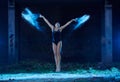 Young woman jumping in blue powder cloud Royalty Free Stock Photo