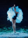 Young woman jumping in blue powder cloud Royalty Free Stock Photo