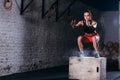 Woman jumping box. Fitness woman doing box jump workout at cross fit gym.