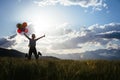 Young woman jumping on grassland with colored balloons Royalty Free Stock Photo