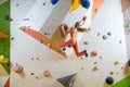 Young woman jumping on handhold in bouldering gym Royalty Free Stock Photo